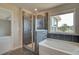 Inviting bathroom featuring a soaking tub, glass-enclosed shower, and large window at 612 Gratton Ln, Mcdonough, GA 30253