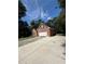 View of the side of a single-story brick home, showcasing a long concrete driveway leading to an attached two-car garage at 709 Stonehenge Pl, Jonesboro, GA 30236