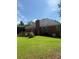 Back exterior featuring brick siding, a wooden deck, and spacious yard at 709 Stonehenge Pl, Jonesboro, GA 30236