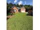 Charming single-story brick home featuring an attached two-car garage and a well-maintained lawn with lovely flower bushes at 709 Stonehenge Pl, Jonesboro, GA 30236