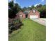 Charming single-story brick home featuring an attached two-car garage and a well-maintained lawn with lovely flower bushes at 709 Stonehenge Pl, Jonesboro, GA 30236
