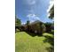 Back exterior showcasing a spacious, green lawn and mature trees at 709 Stonehenge Pl, Jonesboro, GA 30236