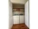 Laundry closet includes a washer, a dryer, and wooden shelving at 709 Stonehenge Pl, Jonesboro, GA 30236