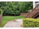 A backyard featuring a well-maintained lawn, privacy fence, wooden staircase and green bushes at 127 Oak Ln, Decatur, GA 30030