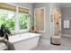Beautiful bathroom with a luxurious soaking tub, herringbone floors, and separate glass shower at 127 Oak Ln, Decatur, GA 30030
