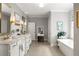 Bathroom with double vanity sinks, soaking tub, herringbone floors, and soft gray paint at 127 Oak Ln, Decatur, GA 30030