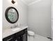 Bathroom with a dark vanity, granite countertop, round mirror, and hexagon tile flooring at 127 Oak Ln, Decatur, GA 30030
