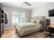 Cozy bedroom with a tufted headboard, wooden floors, and a bright window view at 127 Oak Ln, Decatur, GA 30030