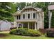 Attractive two-story home with a covered front porch, nestled among mature trees and verdant bushes at 127 Oak Ln, Decatur, GA 30030