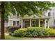 Inviting front porch with plants, ceiling fan, and furniture framed by lush green bushes at 127 Oak Ln, Decatur, GA 30030