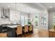 Open concept kitchen with stone countertops, stainless appliances, island seating, and backyard view at 127 Oak Ln, Decatur, GA 30030
