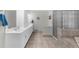 Bright bathroom with double vanity, tiled floors, glass block shower, and separate tub at 340 Helens Manor Dr, Lawrenceville, GA 30045