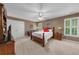 Comfortable bedroom featuring neutral walls, carpet, ceiling fan, and a wooden bed frame with white bedding at 340 Helens Manor Dr, Lawrenceville, GA 30045