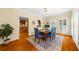 Bright dining room with wood floors, white shutters, and a view into the kitchen area at 340 Helens Manor Dr, Lawrenceville, GA 30045