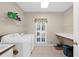 Well-lit laundry room with washer, dryer, storage shelves, and tile flooring at 340 Helens Manor Dr, Lawrenceville, GA 30045