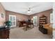Well-lit office features a ceiling fan, large windows, desk, and a bookcase filled with books at 340 Helens Manor Dr, Lawrenceville, GA 30045