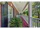 Inviting porch with a cozy seating area, red wood floors, and hanging plants at 340 Helens Manor Dr, Lawrenceville, GA 30045