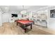 Basement rec room featuring pool table, bar seating and hardwood floors at 7025 Windsor Hill Psge, Suwanee, GA 30024
