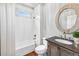 Charming bathroom with wood-look vanity, herringbone tile, and a shower-tub combo at 7025 Windsor Hill Psge, Suwanee, GA 30024