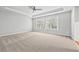 Bright bedroom with tray ceiling, ceiling fan, carpet floors and large window for ample natural light at 7025 Windsor Hill Psge, Suwanee, GA 30024