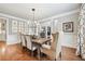 Formal dining room with hardwood floors, crown molding, elegant light fixture and large windows at 7025 Windsor Hill Psge, Suwanee, GA 30024