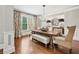 Formal dining room featuring hardwood floors, large windows, elegant drapery, and sophisticated decor at 7025 Windsor Hill Psge, Suwanee, GA 30024