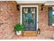 Inviting front entrance with double doors, classic brick, decorative lanterns and a 'Welcome' mat at 7025 Windsor Hill Psge, Suwanee, GA 30024