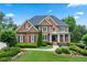 Stately brick home featuring manicured landscaping, a covered porch, and a classic architectural design at 7025 Windsor Hill Psge, Suwanee, GA 30024