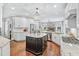 Spacious kitchen features white cabinets, dark island, granite counters, and stainless steel appliances at 7025 Windsor Hill Psge, Suwanee, GA 30024
