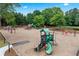 Community playground with multiple slides, swings, and climbing equipment surrounded by lush greenery and mature trees at 7025 Windsor Hill Psge, Suwanee, GA 30024