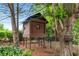 Backyard playhouse set among mature trees and shrubbery, offering a private and fun space for children at 7025 Windsor Hill Psge, Suwanee, GA 30024