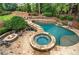 Aerial view of the backyard pool with a spa, waterfall, and firepit at 7025 Windsor Hill Psge, Suwanee, GA 30024