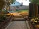 Backyard featuring a stepped stone path leading up to a brick home with mature trees and landscaping at 810 Doe Hill Ln, Roswell, GA 30075