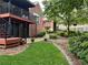 Backyard featuring a deck with stairs, a stone walkway, lush landscaping, and mature trees at 810 Doe Hill Ln, Roswell, GA 30075