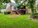 Expansive backyard featuring a deck with stairs, vibrant green lawn, and mature landscaping elements at 810 Doe Hill Ln, Roswell, GA 30075