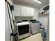 Functional laundry room with washer, dryer, and storage shelves at 810 Doe Hill Ln, Roswell, GA 30075