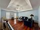 Spacious living room with tray ceiling, hardwood floors, and a comfortable seating arrangement at 810 Doe Hill Ln, Roswell, GA 30075