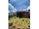 View of brick home's backyard featuring a grassy lawn and partial privacy fence at 1165 Vineyard Ct, Stone Mountain, GA 30083
