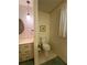 A vintage bathroom featuring a toilet, vanity, and light fixture, exuding a cozy and timeless feel at 1165 Vineyard Ct, Stone Mountain, GA 30083