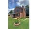 Exterior view of brick home with front lawn, landscaping, and mature trees at 1165 Vineyard Ct, Stone Mountain, GA 30083