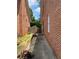 Side yard view of brick house with landscaped walkway and fencing at 1165 Vineyard Ct, Stone Mountain, GA 30083