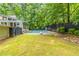 Large green backyard with a pool, mature trees, and the back exterior of the house at 1282 Shiloh Trail E, Kennesaw, GA 30144