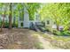 View of home featuring mature trees, a deck, stairs, and fresh landscaping at 1282 Shiloh Trail E, Kennesaw, GA 30144