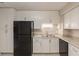 This kitchen features bright white cabinetry, a black appliance suite, and neutral countertops at 1282 Shiloh Trail E, Kennesaw, GA 30144