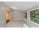 Bright living room with tile floors, neutral walls, and a wall of windows overlooking the surrounding trees at 1282 Shiloh Trail E, Kennesaw, GA 30144