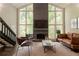 Bright living room with a stone fireplace, leather furniture, and large picturesque windows at 1282 Shiloh Trail E, Kennesaw, GA 30144