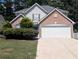 Charming two-story home featuring a brick facade, blue front door, and attached two-car garage at 2234 Oakland Springs Dr, Snellville, GA 30039