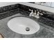 Close-up of bathroom sink with black granite countertop and chrome faucet at 1445 Monroe Ne Dr # C32, Atlanta, GA 30324