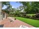 Inviting backyard featuring a brick patio, lush lawn, charming landscaping, and Adirondack seating at 300 Stone Mill Trl, Atlanta, GA 30328