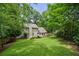Sprawling, green backyard with mature trees and a patio area for relaxing or entertaining at 300 Stone Mill Trl, Atlanta, GA 30328